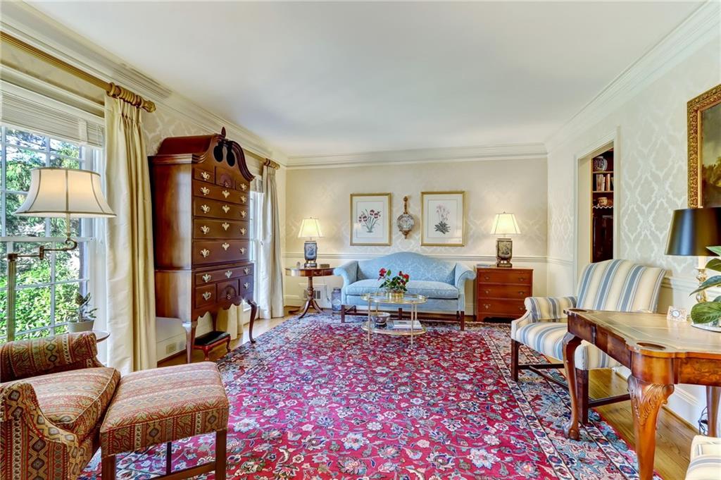 Living room featuring plenty of natural light, crown molding, and hardwood / wood-style flooring