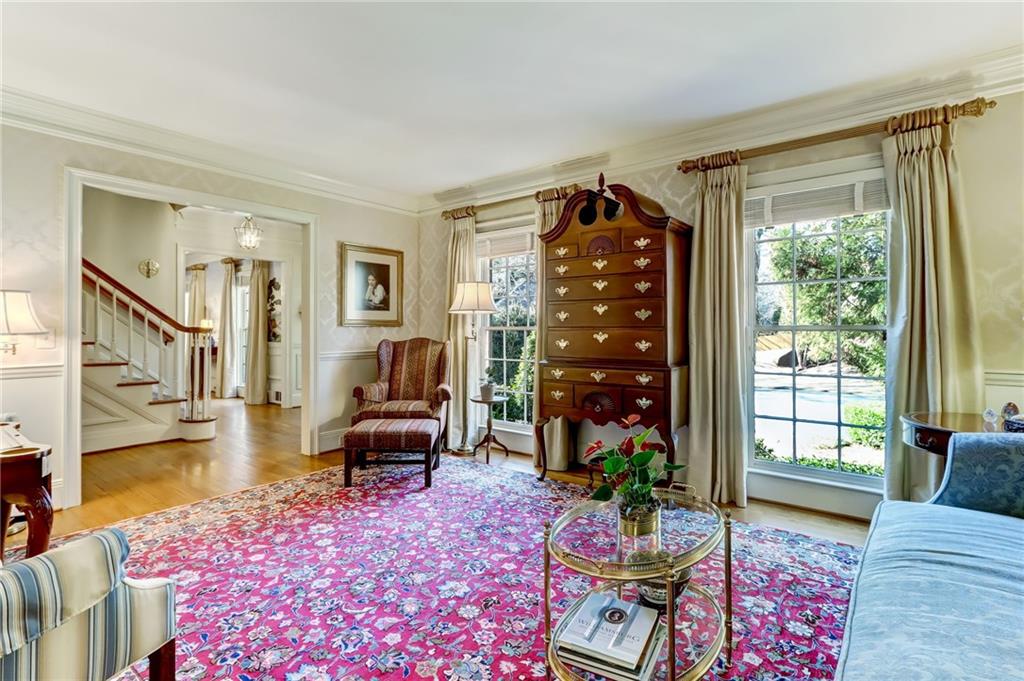 Living room with a wealth of natural light, light hardwood / wood-style floors, and ornamental molding