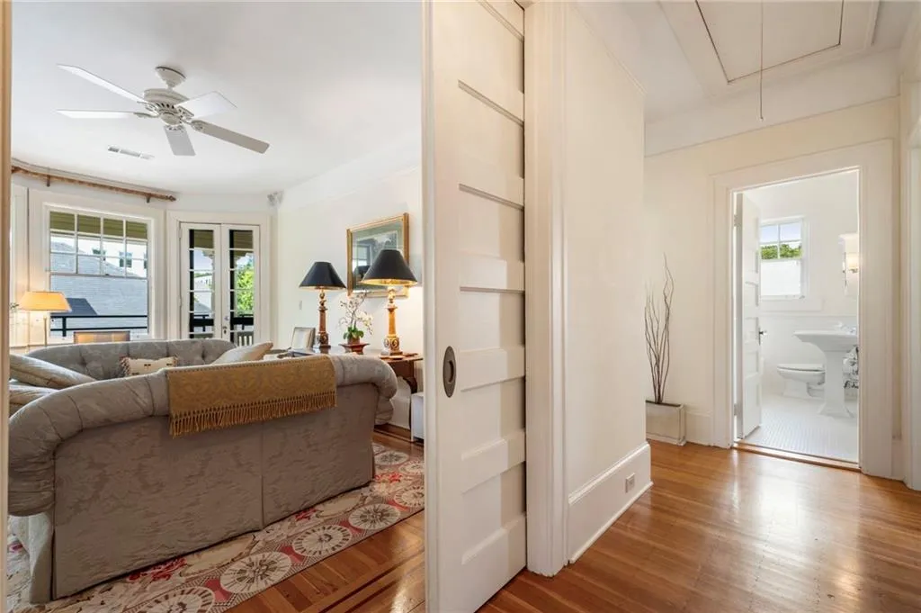 Living room with plenty of natural light, attic access, wood finished floors, and ceiling fan