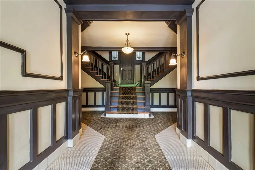Stairs featuring a decorative wall and a wainscoted wall