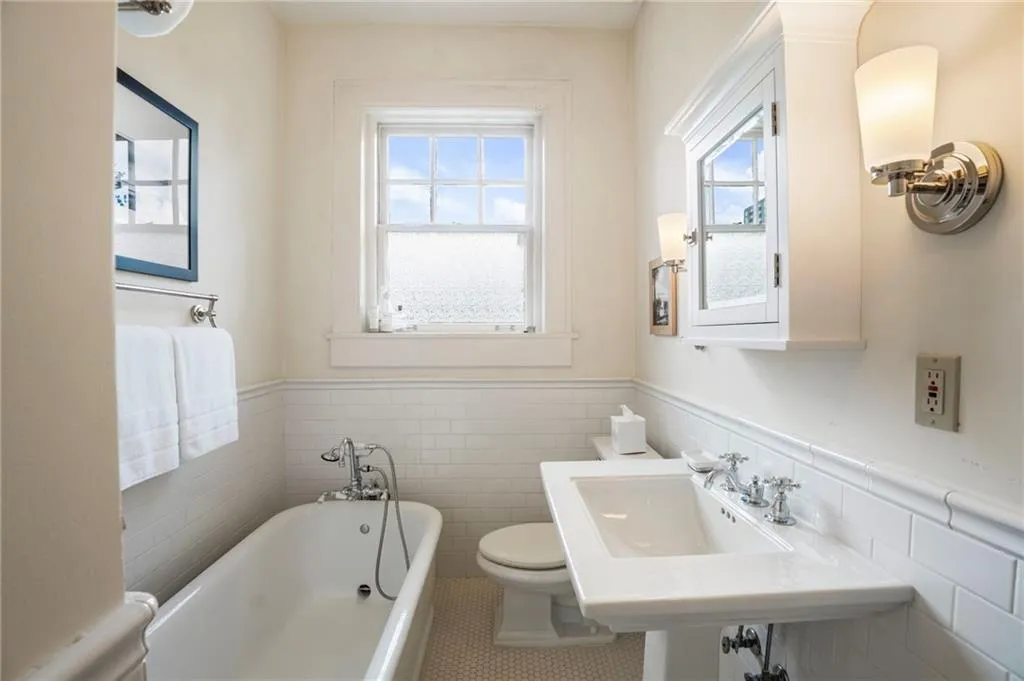 Full bath with a bath, a wainscoted wall, and tile walls