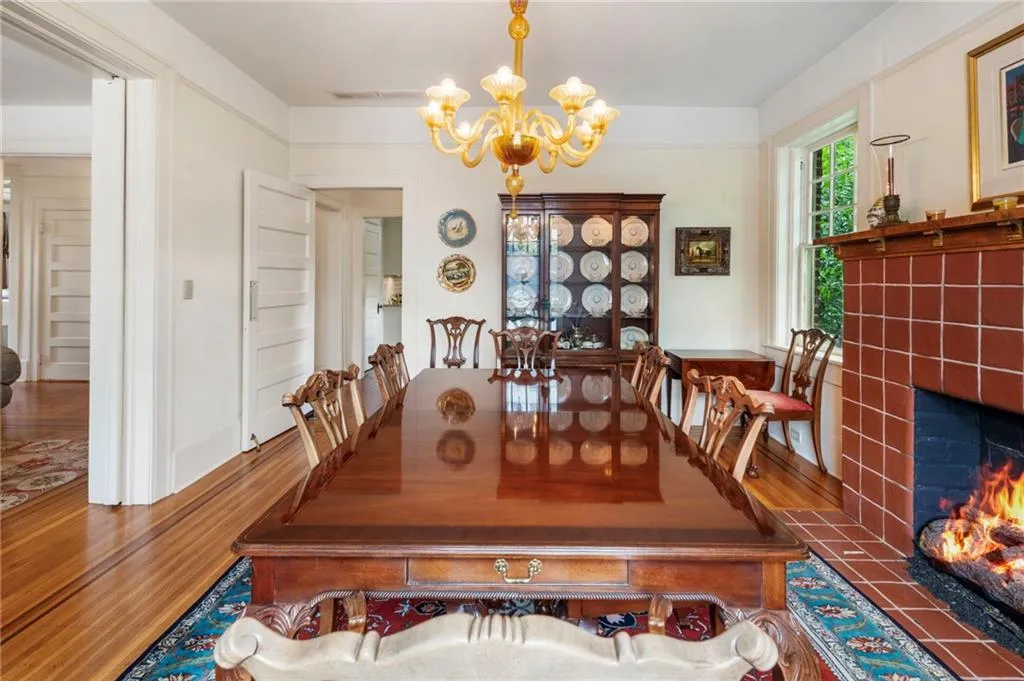 Dining room with a tiled fireplace, a chandelier, and wood finished floors