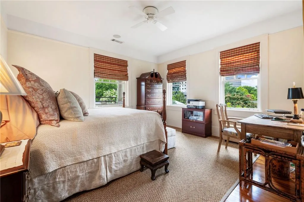 Bedroom featuring light wood-style floors, a ceiling fan, and a desk