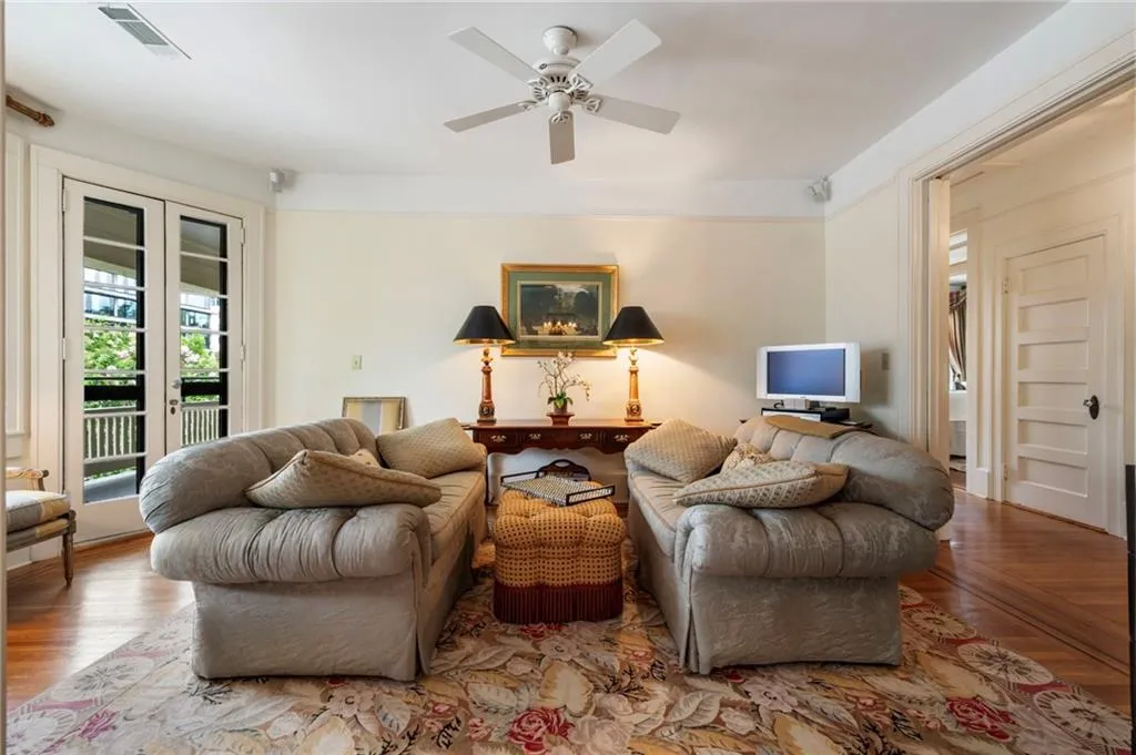 Sitting room featuring wood finished floors, a ceiling fan, and french doors