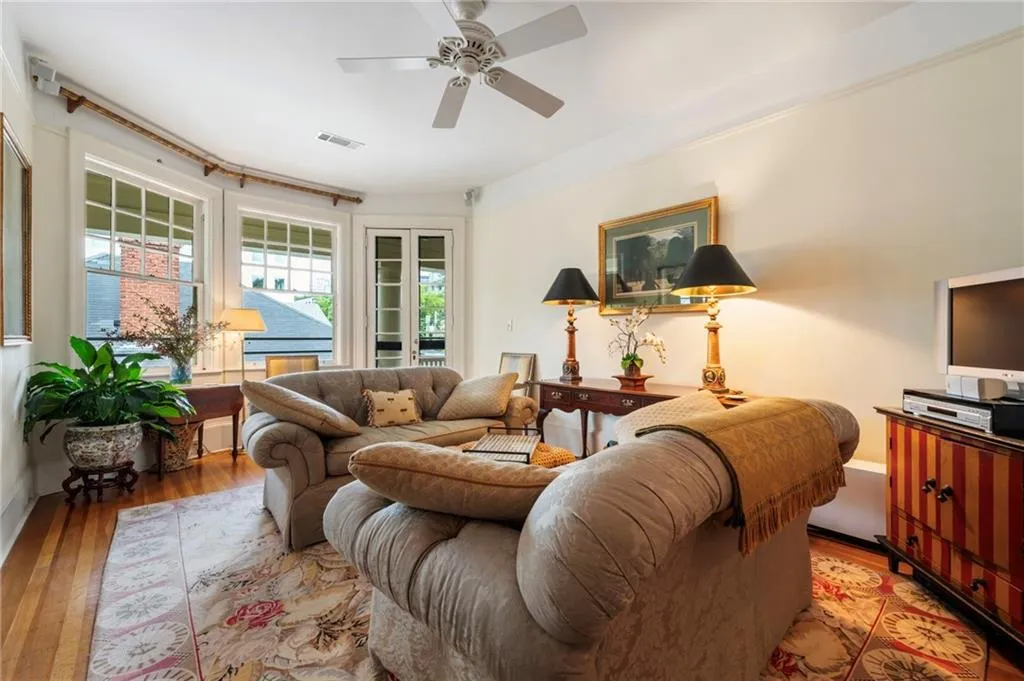 Living area featuring wood-type flooring and a ceiling fan