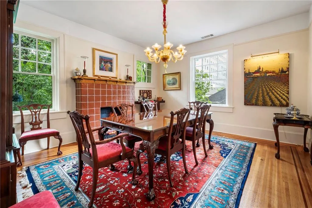 Dining room featuring wood finished floors, a chandelier, and a tiled fireplace
