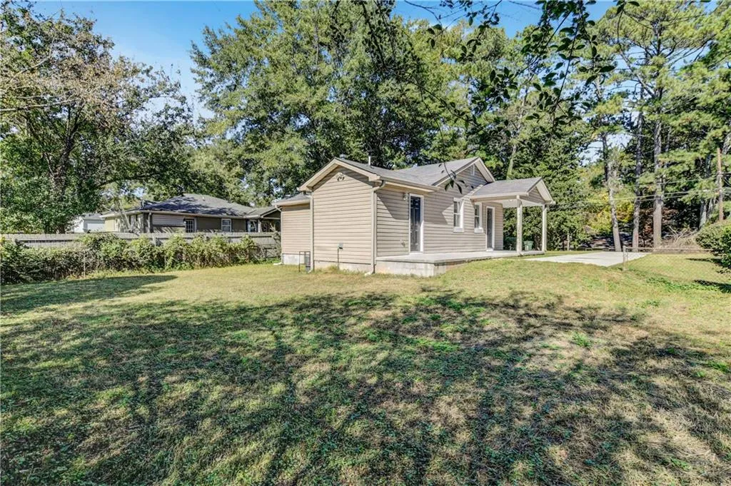 View of property exterior featuring view of wooded area