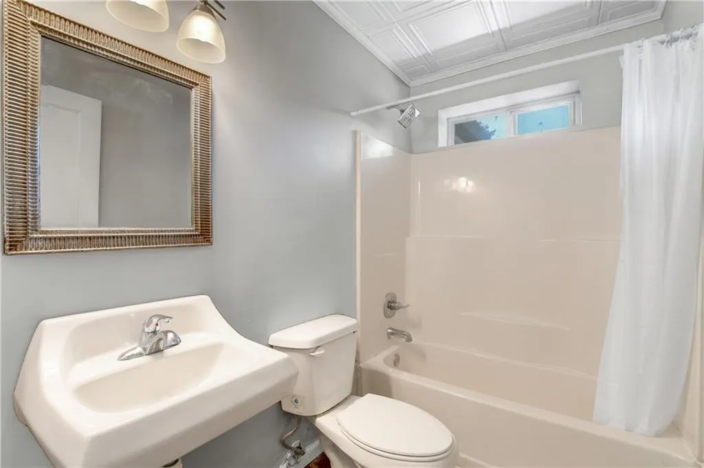Bathroom featuring an ornate ceiling and shower / tub combo with curtain