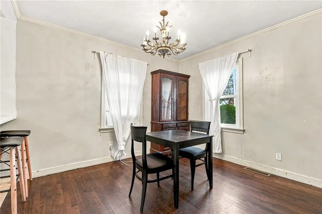 Hardwood-finish flooring, crown molding, and two windows with trim