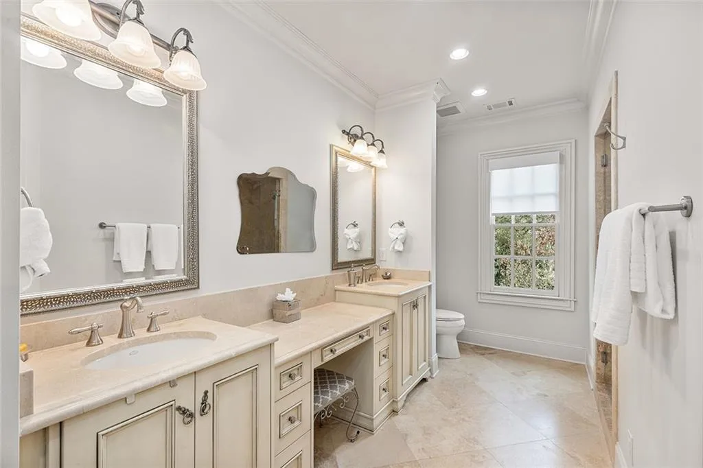 Full bathroom featuring double vanity, crown molding, recessed lighting, and light tile patterned flooring
