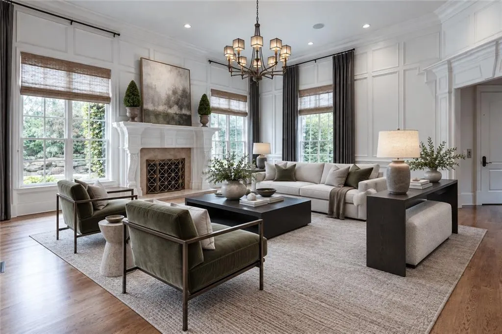 Hardwood flooring throughout, featuring a substantial fireplace with an ornate mantel, panel molding on walls, recessed lighting, and a multi-arm chandelier