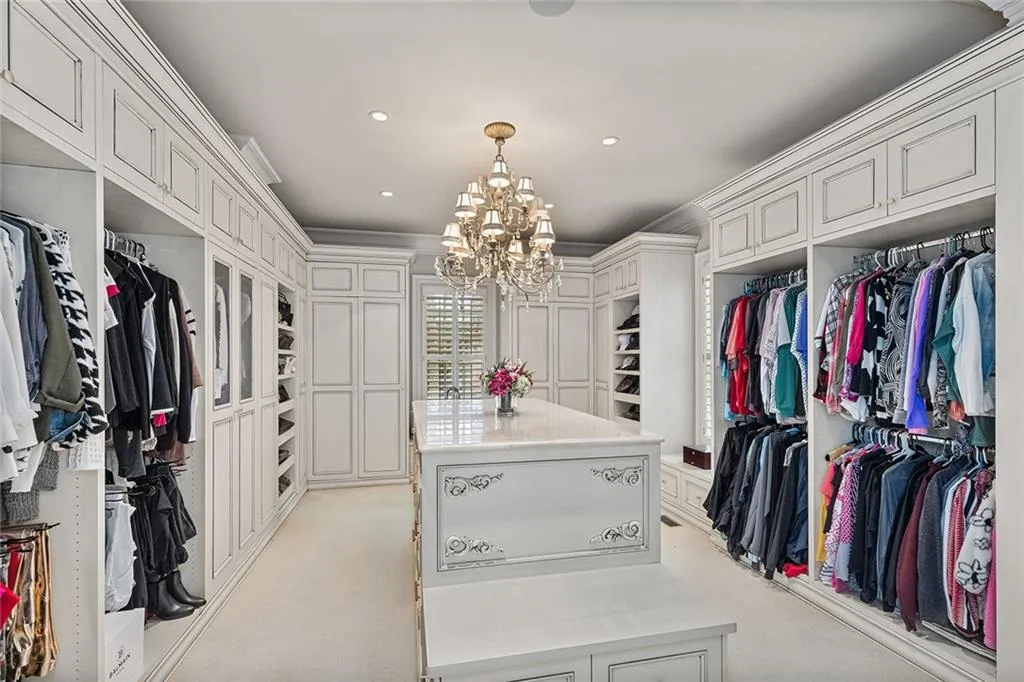 Walk in closet featuring light colored carpet and hanging lights