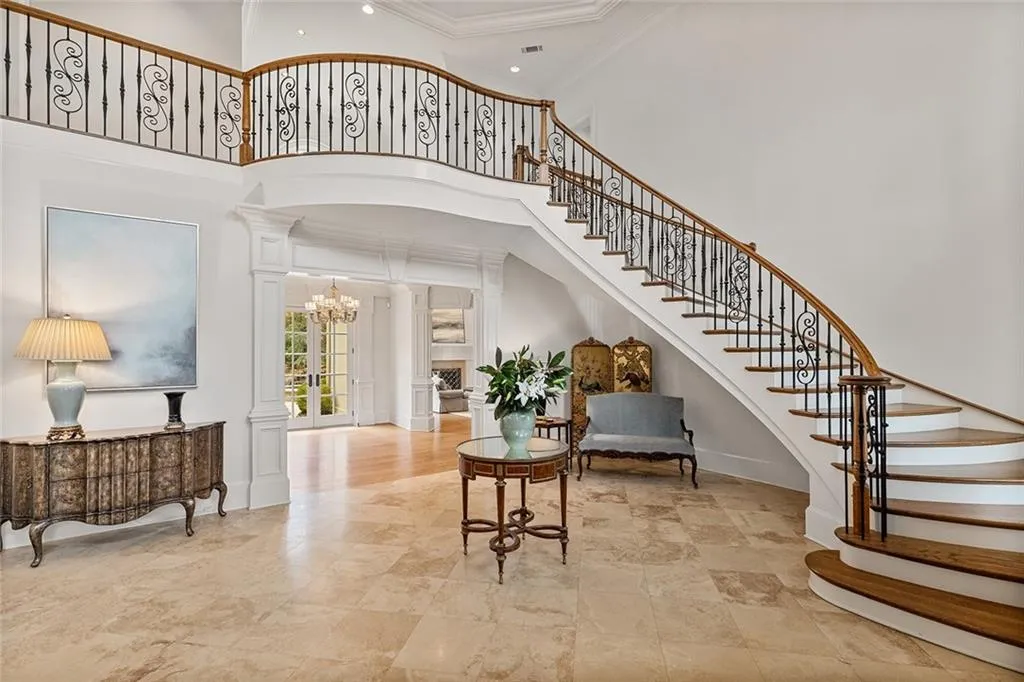 Foyer featuring ornate columns, a high ceiling, and crown molding