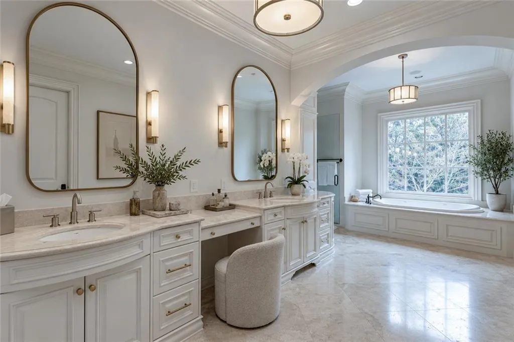 Dual vanity with undermount sinks, stone countertops, and arched mirrors, steam shower