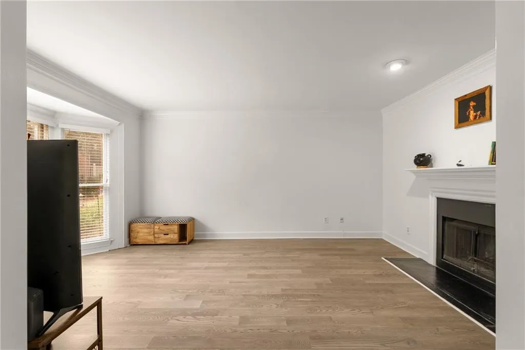 Living room with light hardwood / wood-style flooring and crown molding