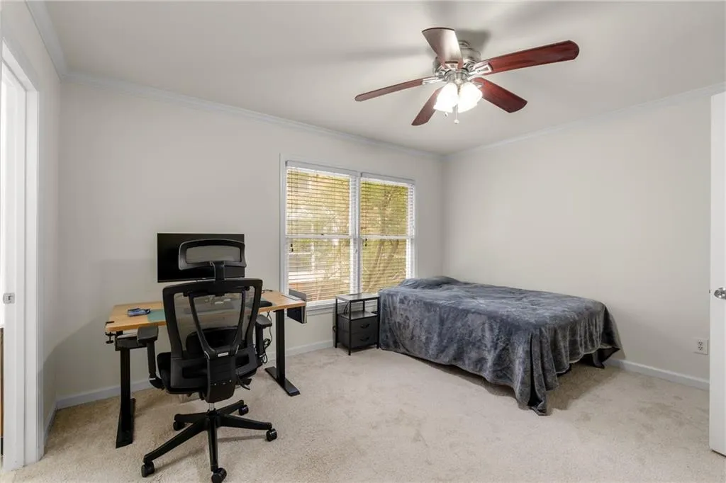 Bedroom featuring ornamental molding, ceiling fan, and light carpet