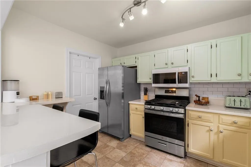 Kitchen featuring appliances with stainless steel finishes and tasteful backsplash