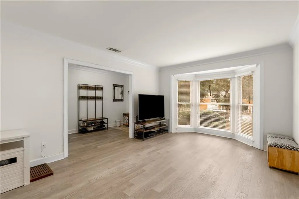 Living room featuring crown molding and light hardwood / wood-style flooring