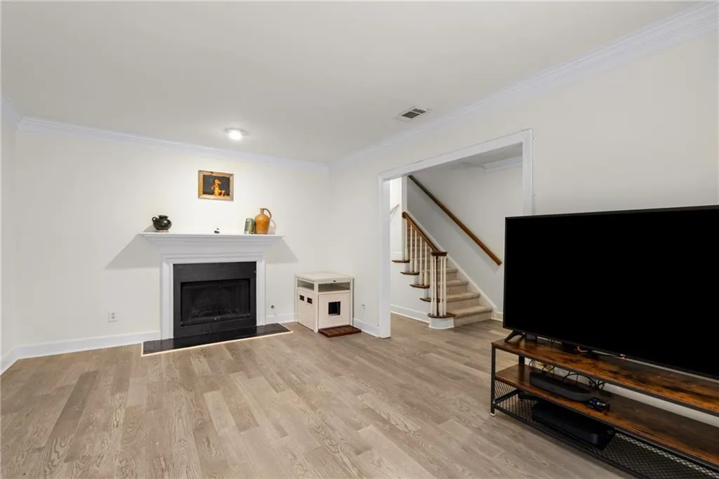 Living room with ornamental molding and light hardwood / wood-style flooring