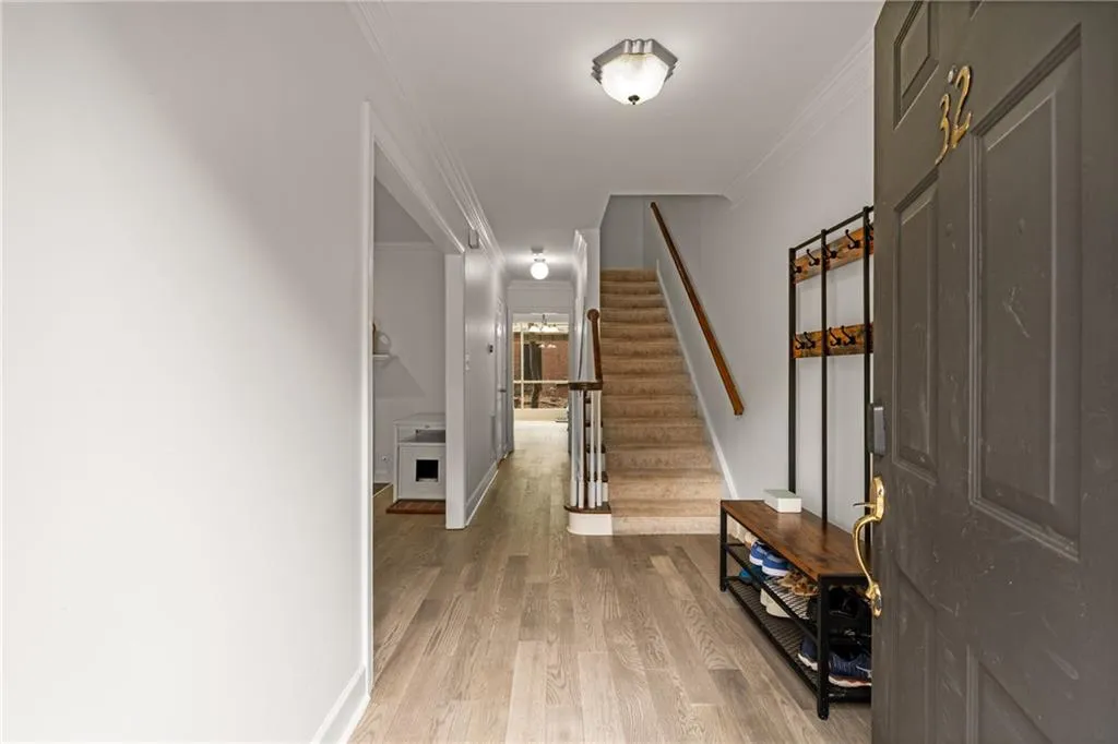 Foyer entrance with light wood-type flooring and crown molding