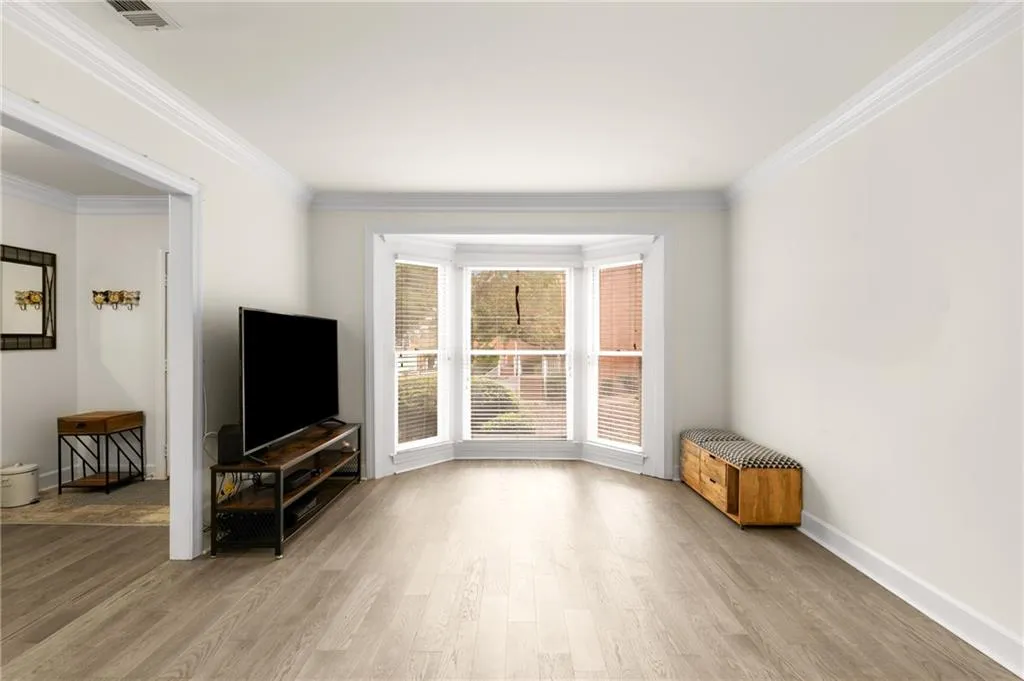 Unfurnished living room with light hardwood / wood-style flooring and ornamental molding