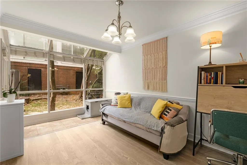 Sitting room with ornamental molding, a chandelier, and light hardwood / wood-style floors