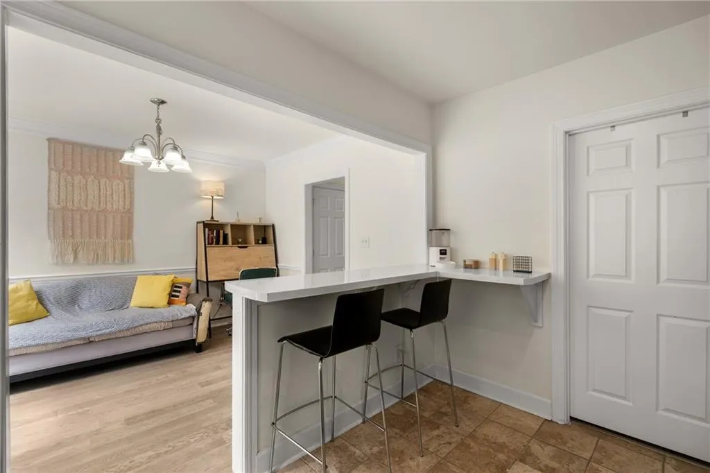 Kitchen featuring pendant lighting, kitchen peninsula, a kitchen breakfast bar, an inviting chandelier, and light hardwood / wood-style floors