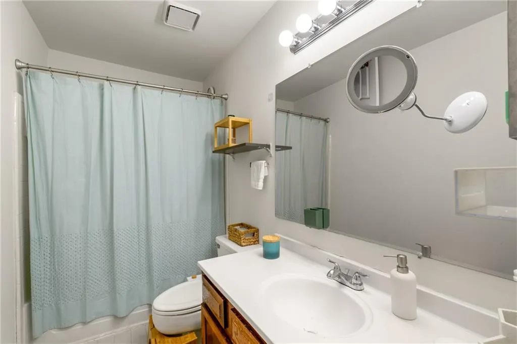 Full bathroom with vanity, toilet, and shower / tub combo with curtain