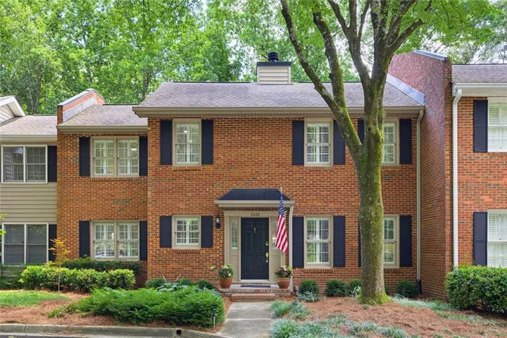 Brick facade property with a dark entry door and white trim windows