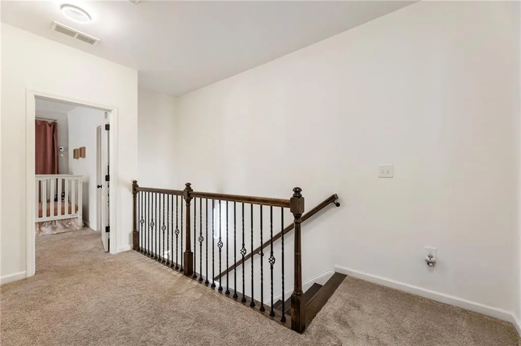 Hall featuring an upstairs landing and carpet flooring