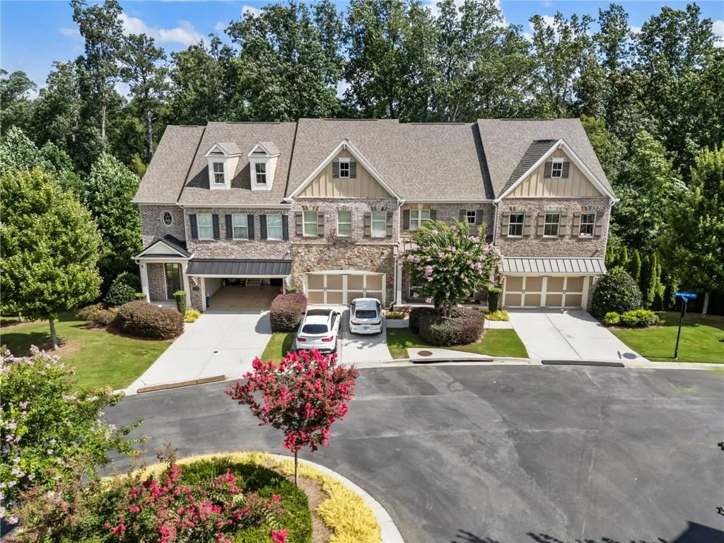 Craftsman inspired home with board and batten siding, stone siding, driveway, and an attached garage