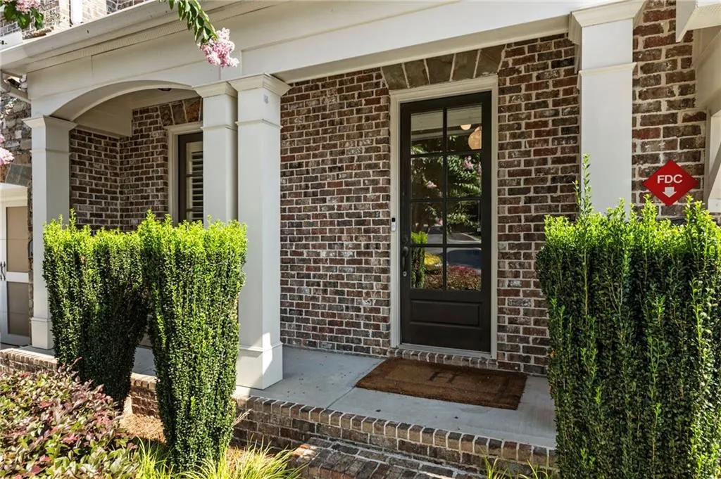 Entrance to property featuring brick siding and covered porch