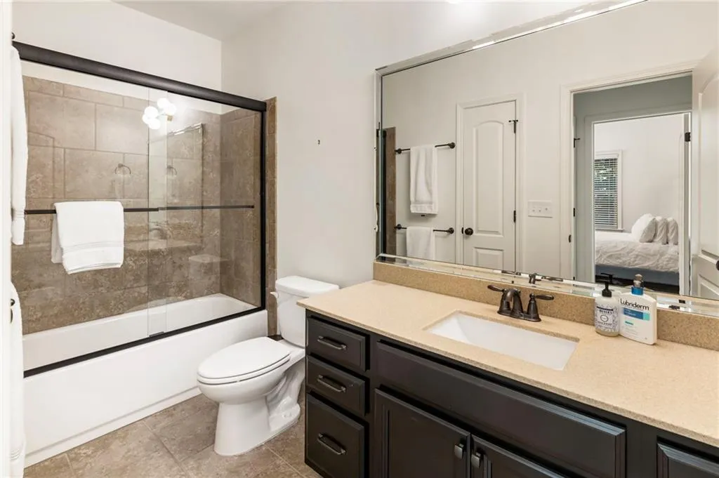 Ensuite bathroom with vanity and shower / bath combination with glass door