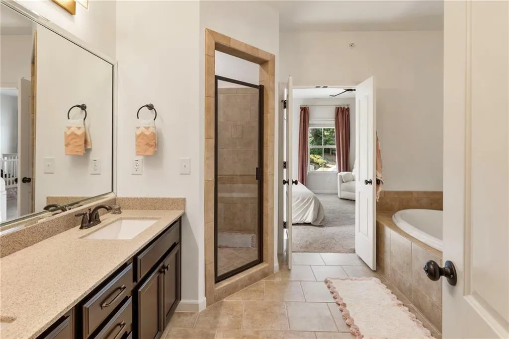 Bathroom with ensuite bathroom, vanity, tile patterned floors, and a shower stall