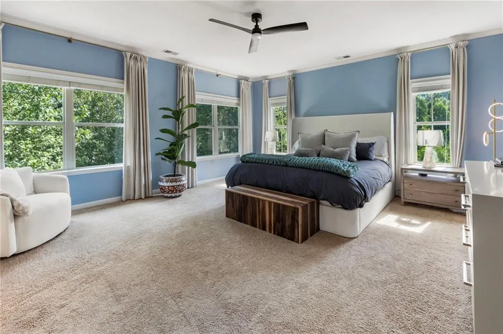 Bedroom with carpet flooring, ceiling fan, and ornamental molding