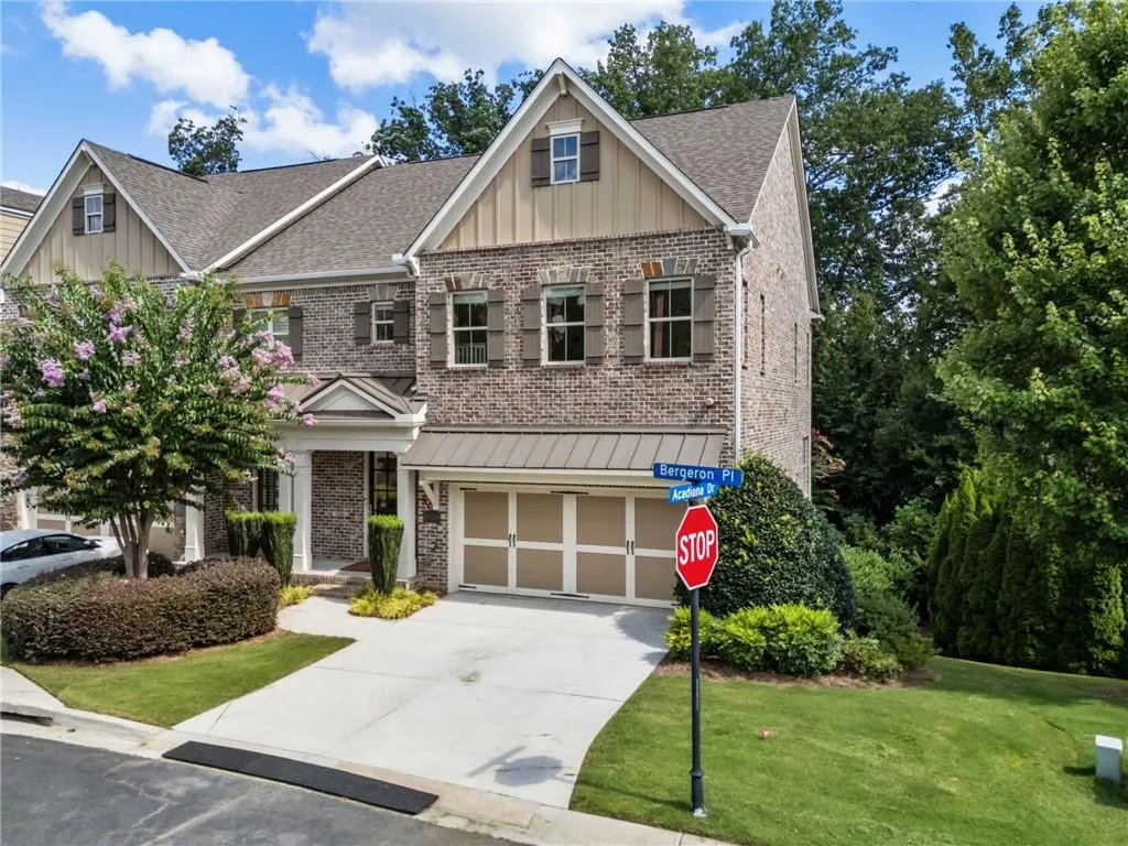 Craftsman-style home with a front lawn, an attached garage, board and batten siding, driveway, and brick siding