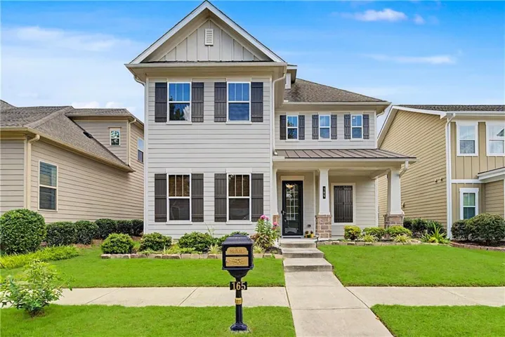 Two-story residence featuring siding exterior, stone accents, and a covered front porch with columns