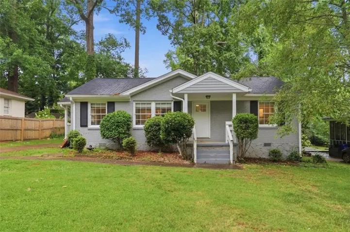 Ranch-style residence featuring a gray brick and siding exterior, white trim, and a dark shingle roof