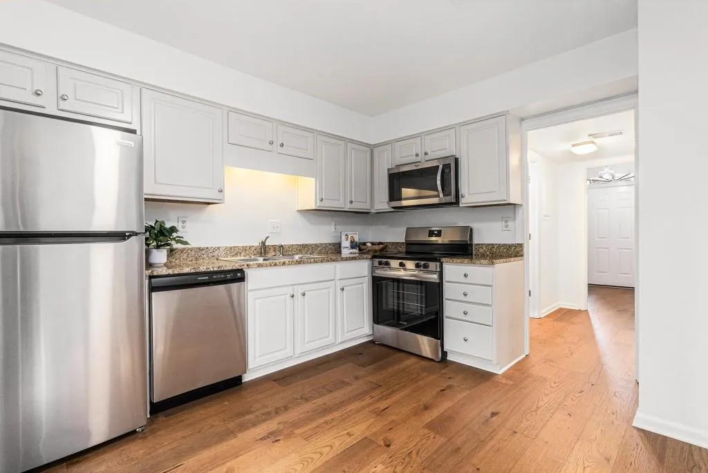 Bright, White Kitchen With Granite Countertops & Stainless Steel Appliances