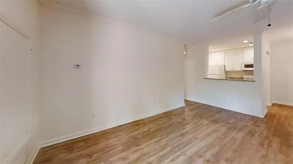Unfurnished living room with ceiling fan, light wood finished floors, recessed lighting, and crown molding
