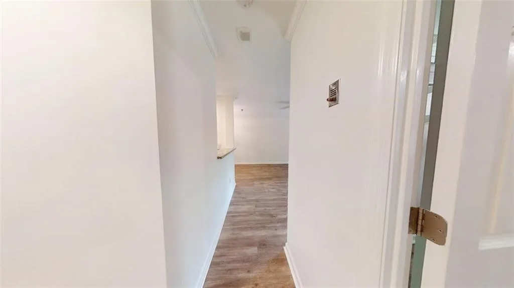 Hall with light wood-style floors and crown molding