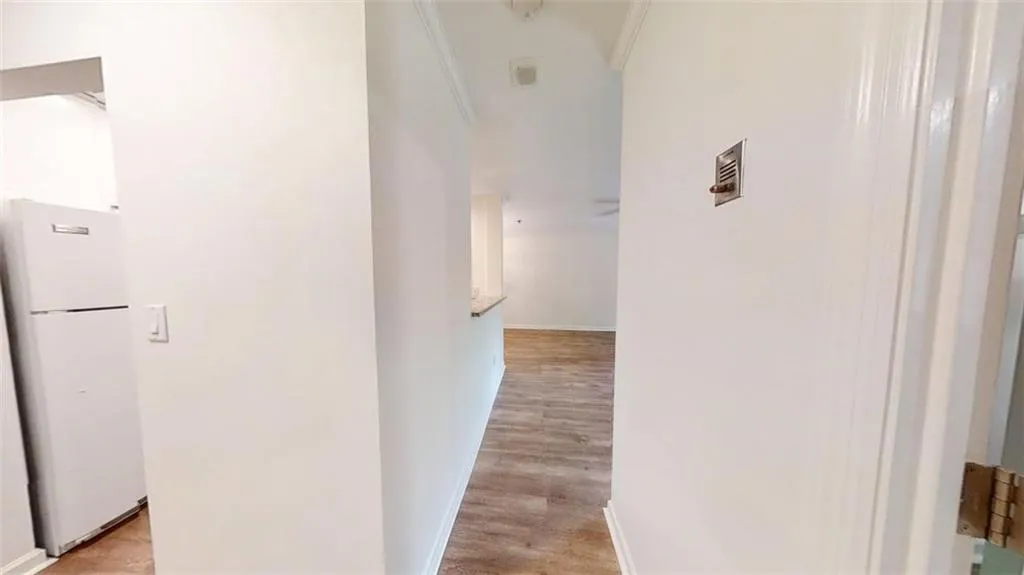 Hallway featuring light wood-style floors and crown molding