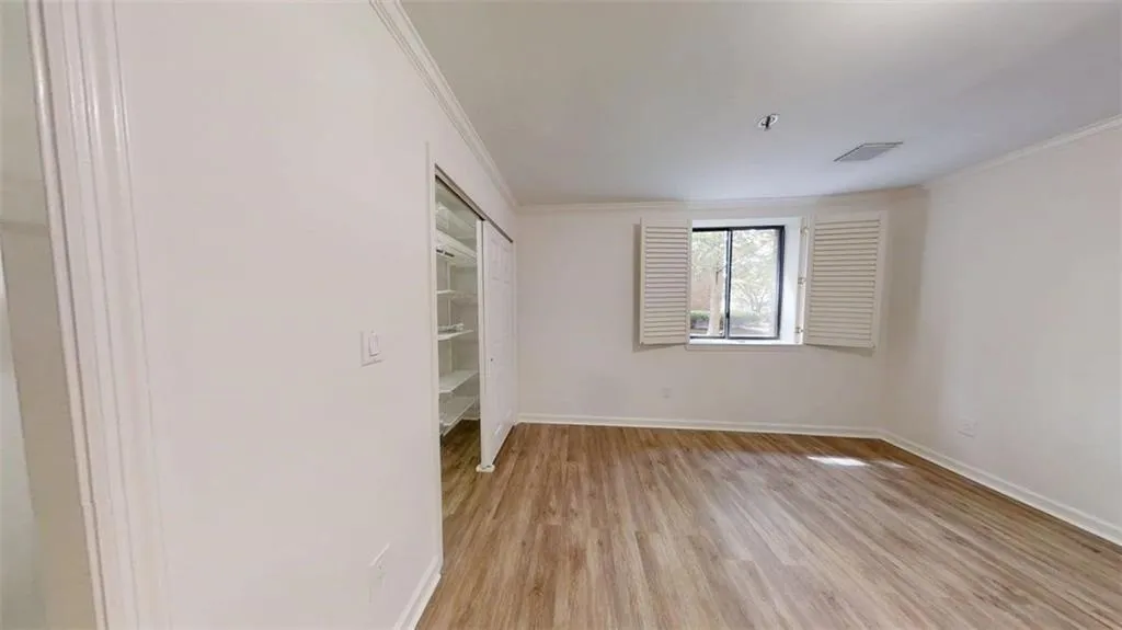 Unfurnished bedroom with light wood finished floors and crown molding