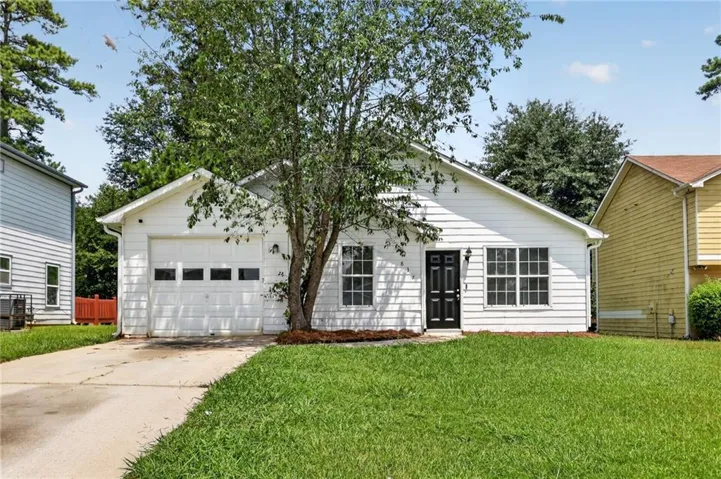 White siding exterior with a dark entry door, multiple pane windows, an attached single-car garage, and a concrete driveway