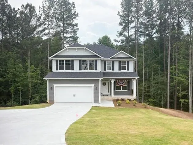 Two-story residence with a covered front porch, attached two-car garage, dark gray shingle roof, and light gray siding