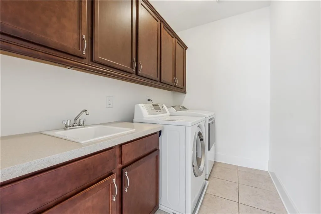 Second floor laundry room has sink and lots of storage cabinets