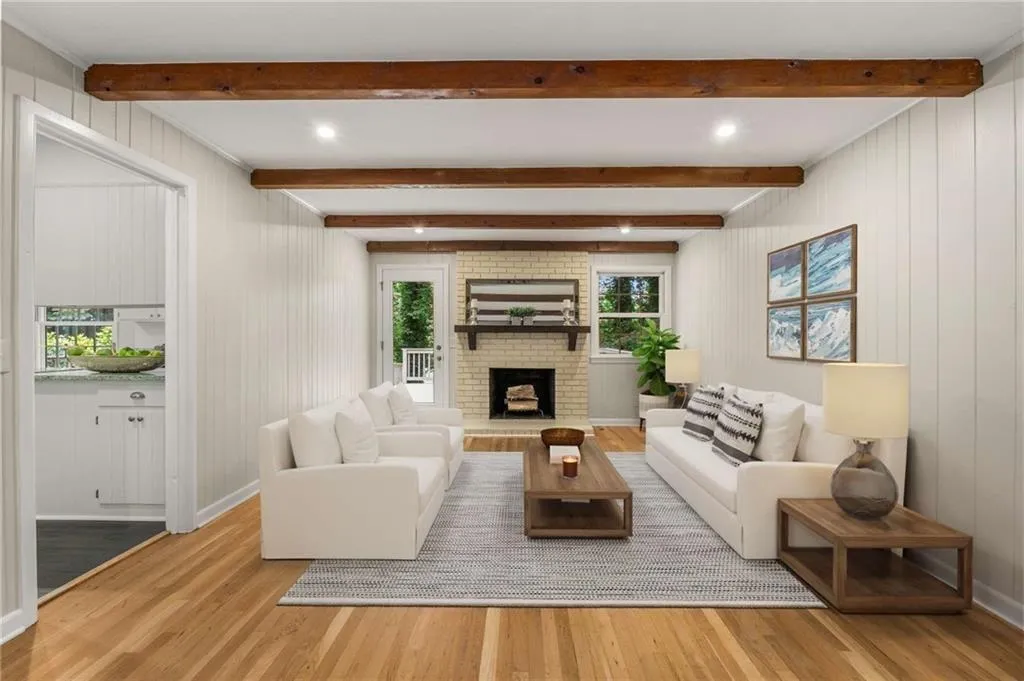 Living area with light wood-style flooring, healthy amount of natural light, beamed ceiling, a fireplace, and recessed lighting