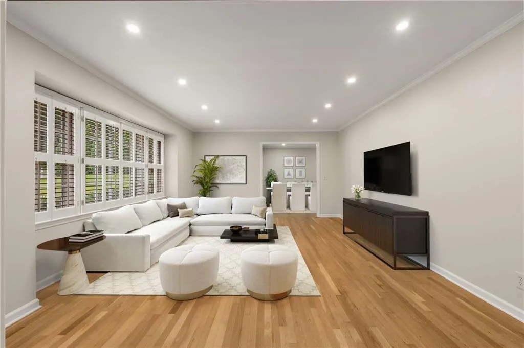 Living area with light wood-style floors, ornamental molding, and recessed lighting