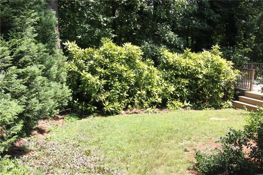 View of grassy yard featuring a wooden deck