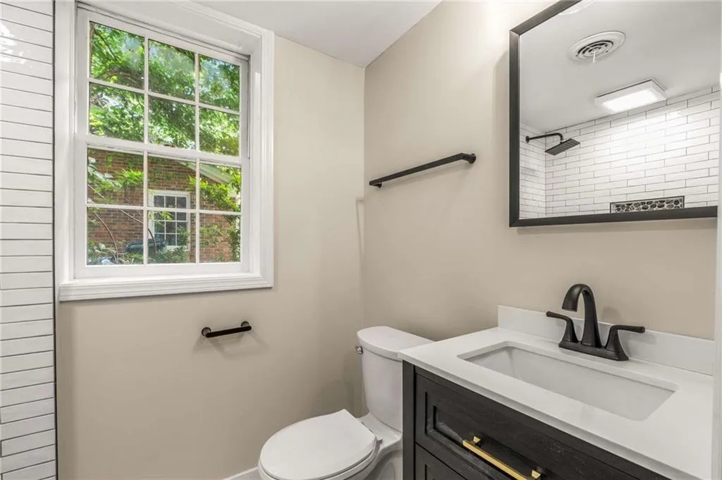 Full bath with healthy amount of natural light, vanity, and a shower in Basement.